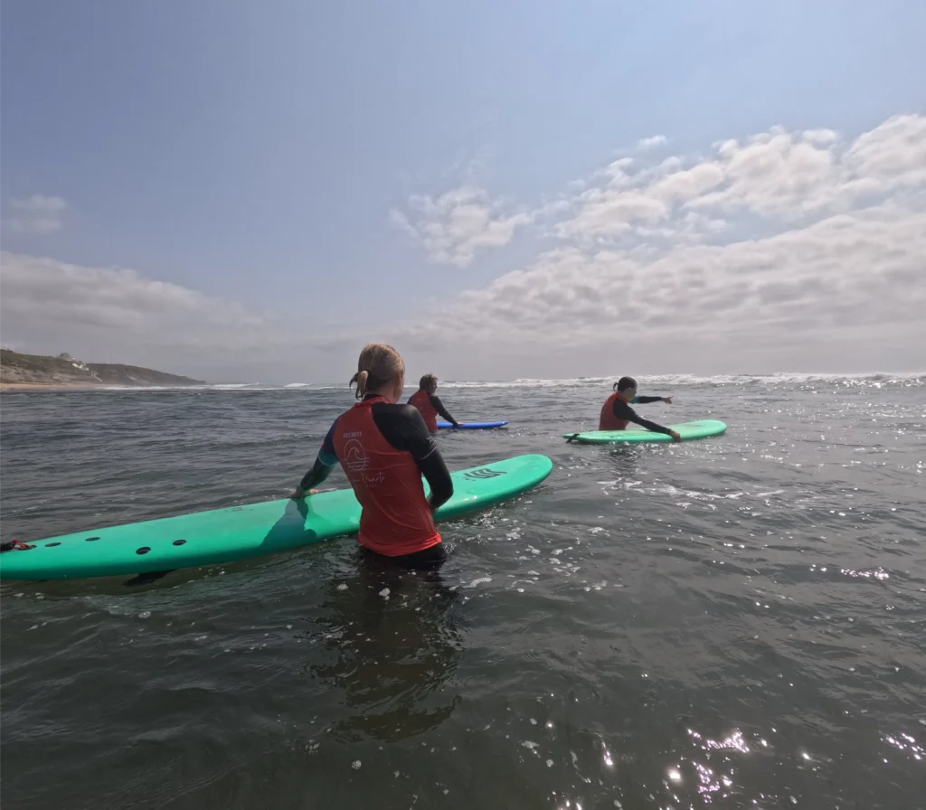 People in water at beach surfing